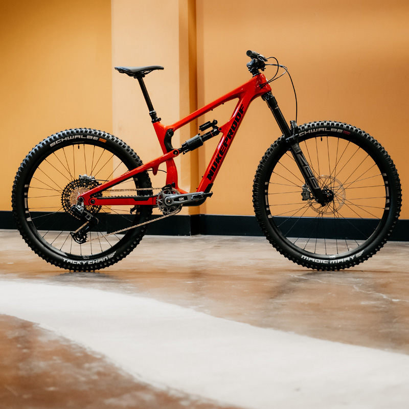 Nukeproof Mega Carbon 297 volledig zijaanzicht op witte achtergrond — 29 inch voor, 27.5 inch achter, RockShox Zeb vork, SRAM GX Transmission